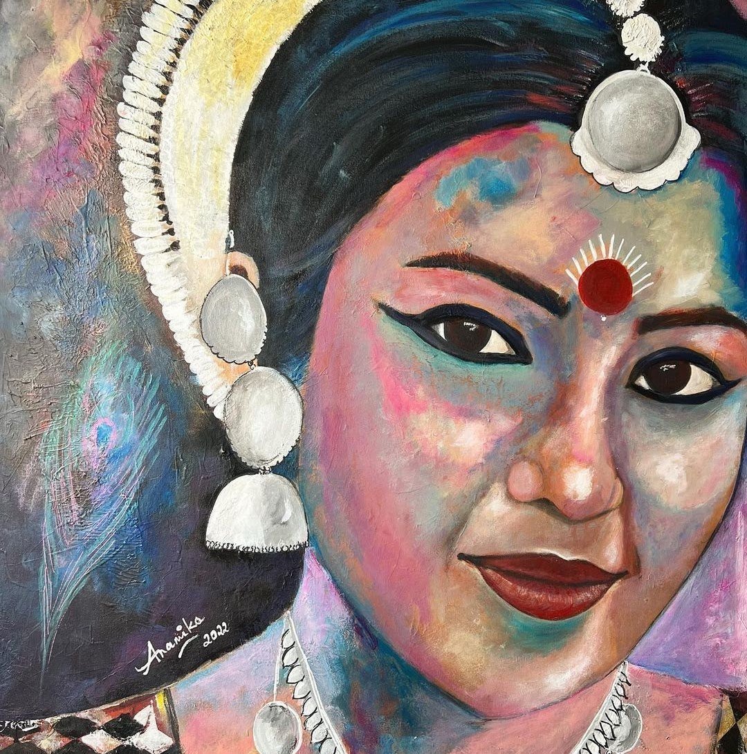 A woman with a red bindi, kohl eyes and silver jhumkas in vivid colour
