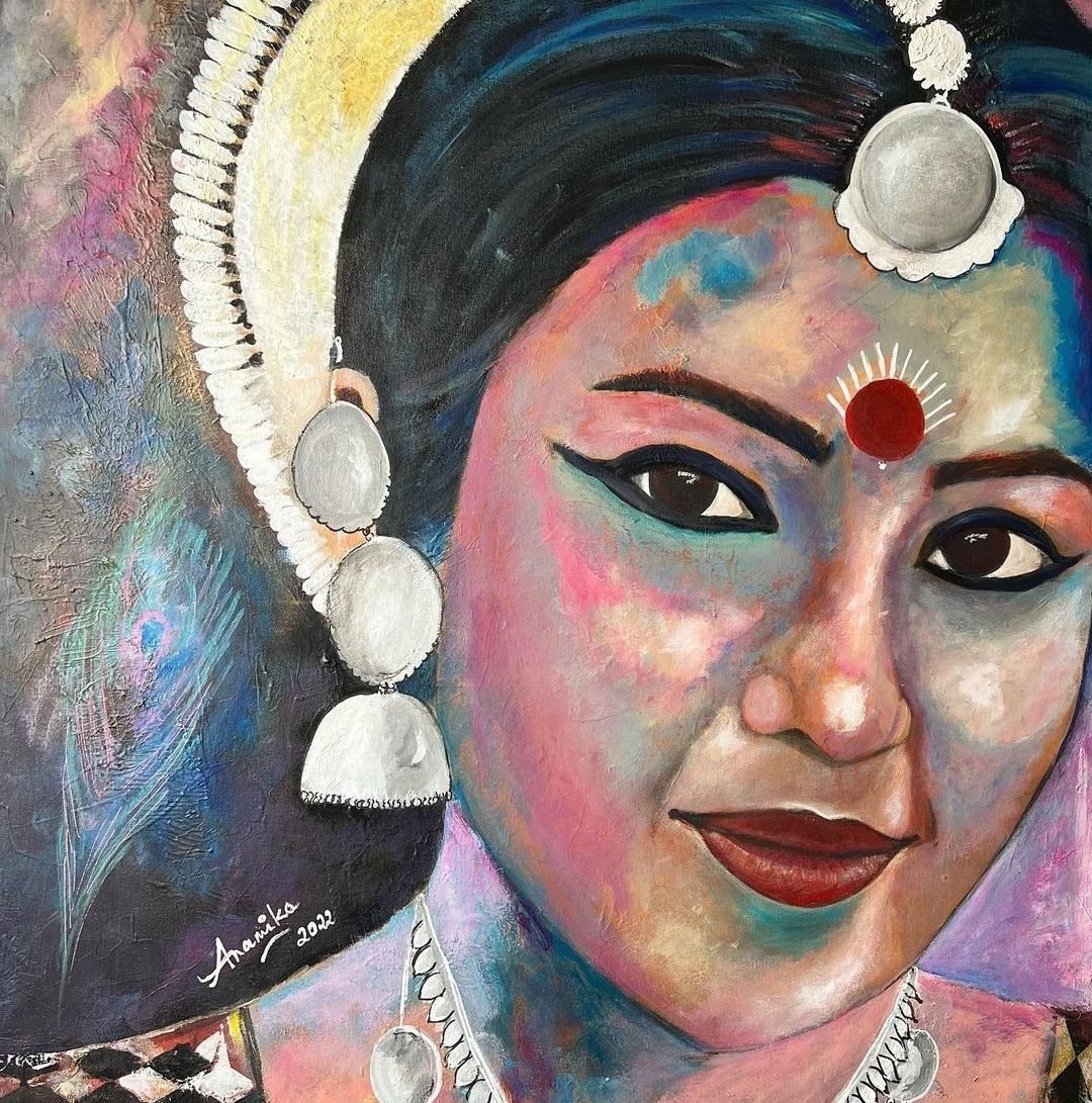 A woman with a red bindi, kohl eyes and silver jhumkas in vivid colour