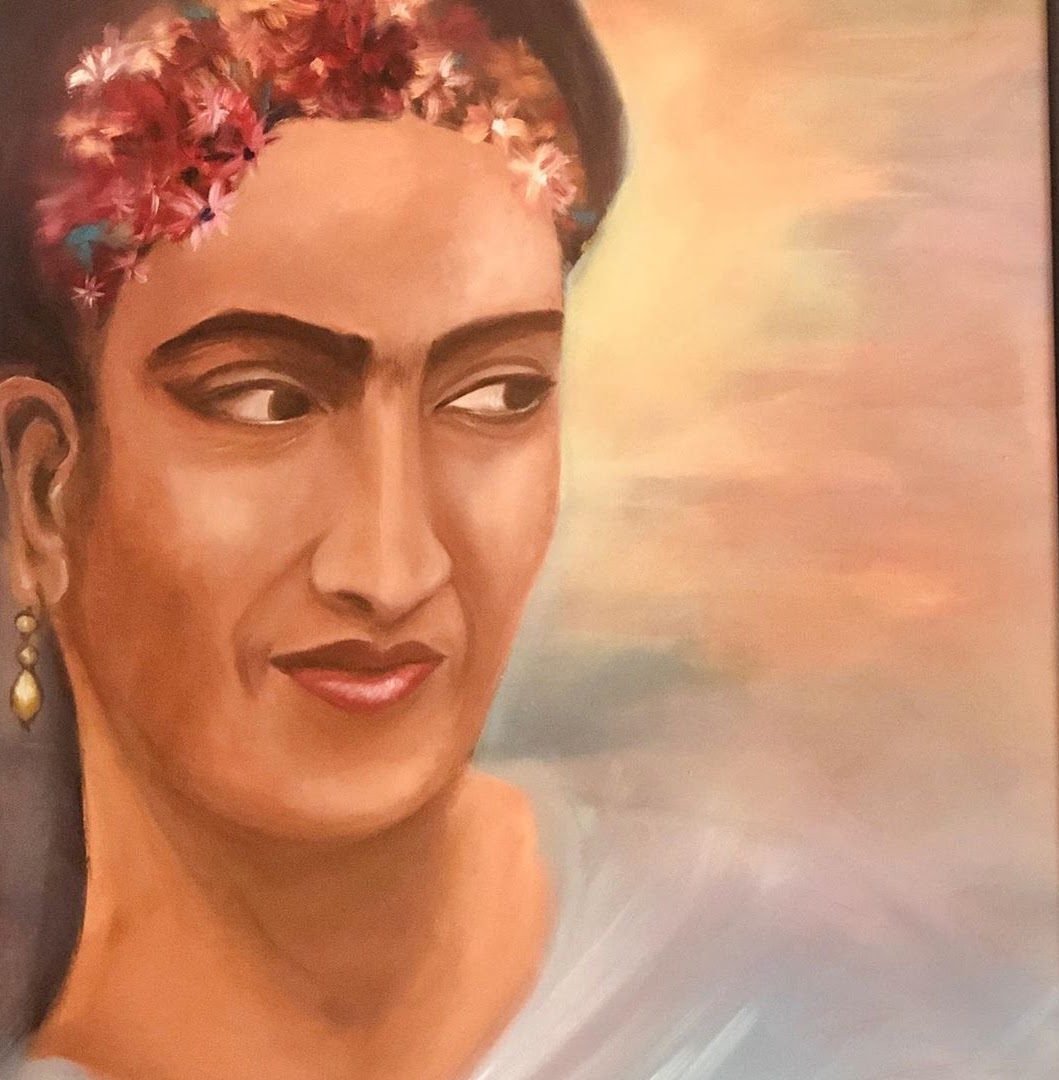 A woman with flowers in her hair and gold earrings against a pale sky