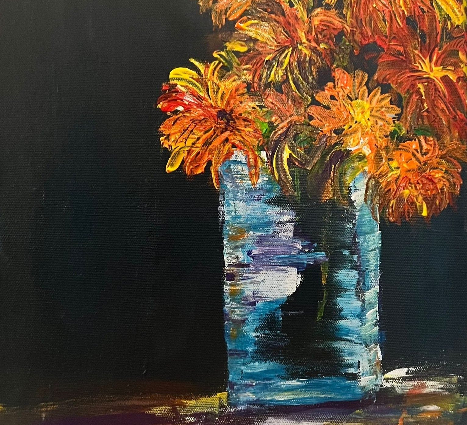Orange marigolds in a glass jar against a dark ground