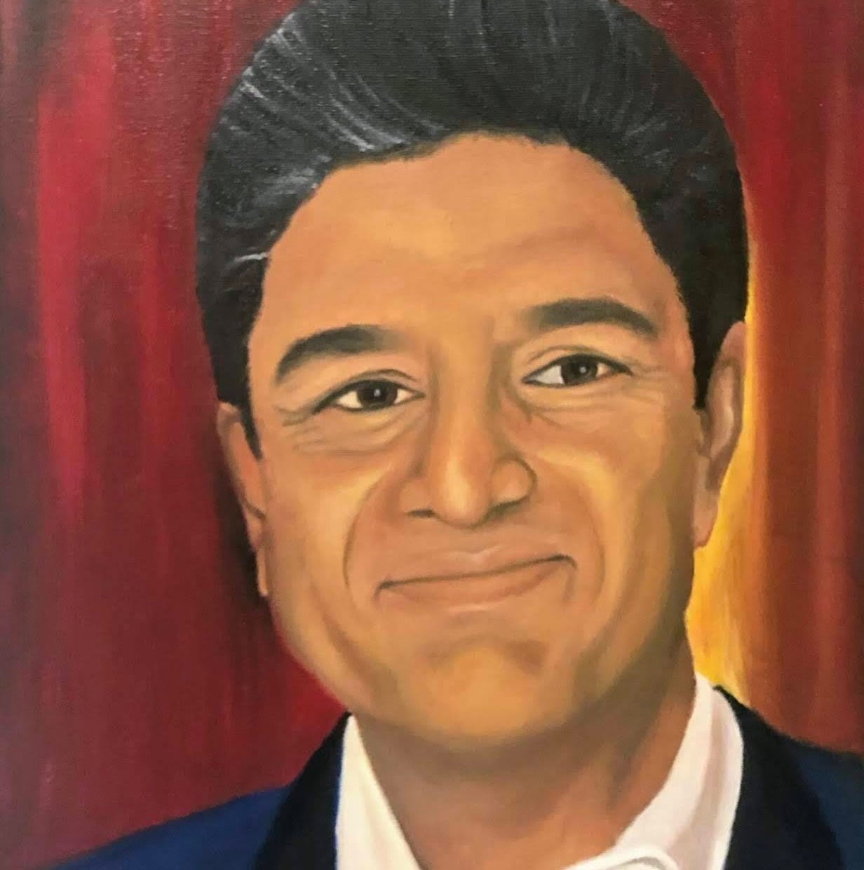 Portrait of a smiling man in a dark suit against red