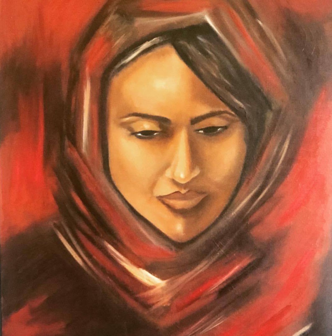 A woman wrapped in a red scarf, gazing down