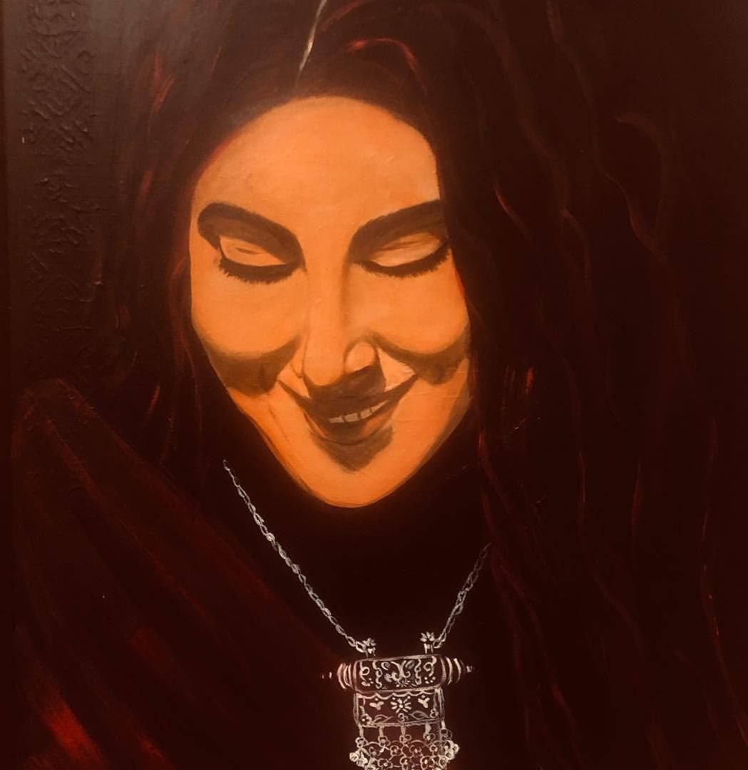 A woman with closed eyes in deep red shadow wearing a silver pendant